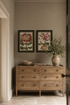 hallway with Liliaceo pair of wall art above a modern country inspired chest of drawers with a vase filled with faux foliage