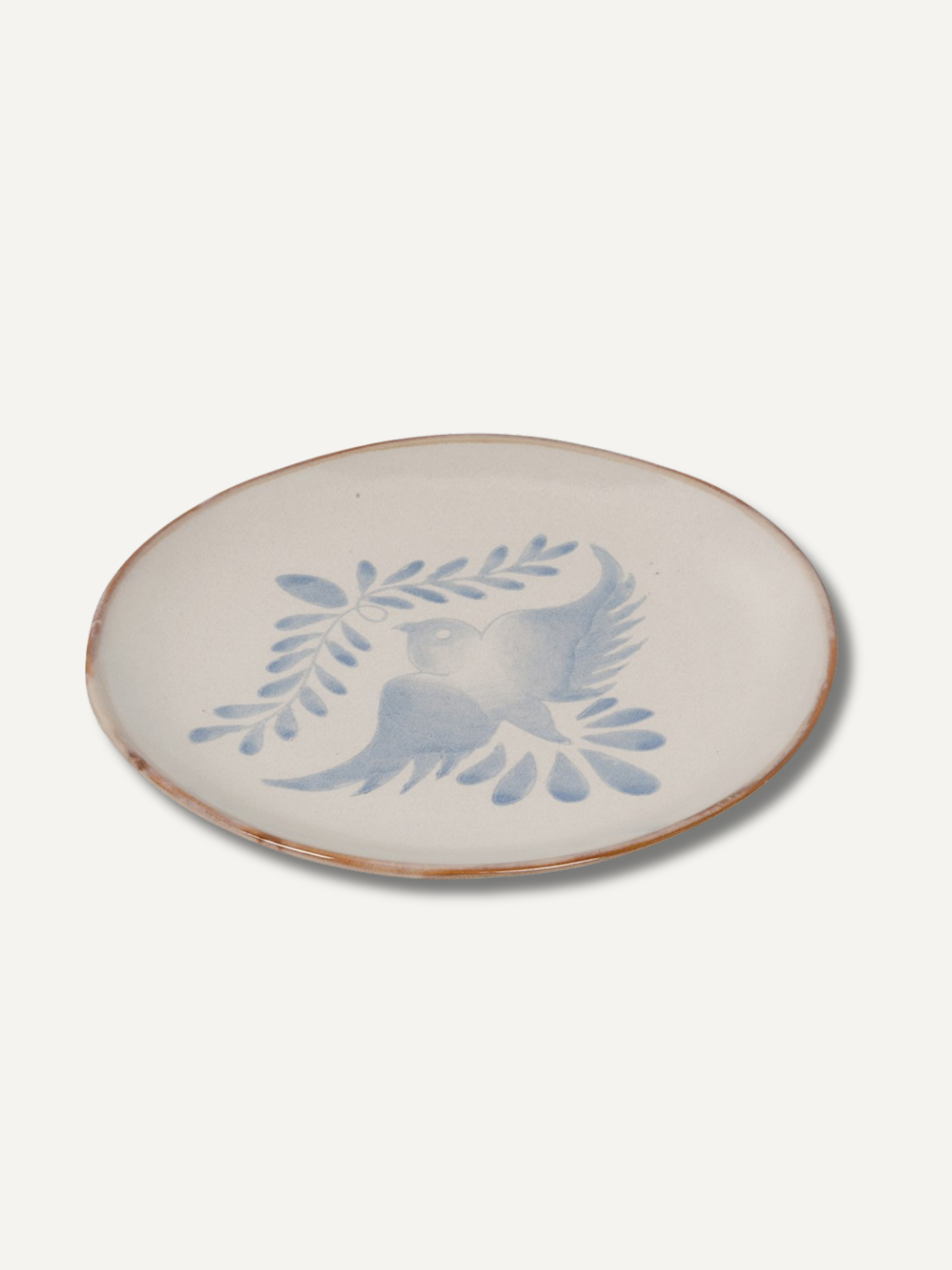 Ceramic plate with blue bird and leaf design on a white background