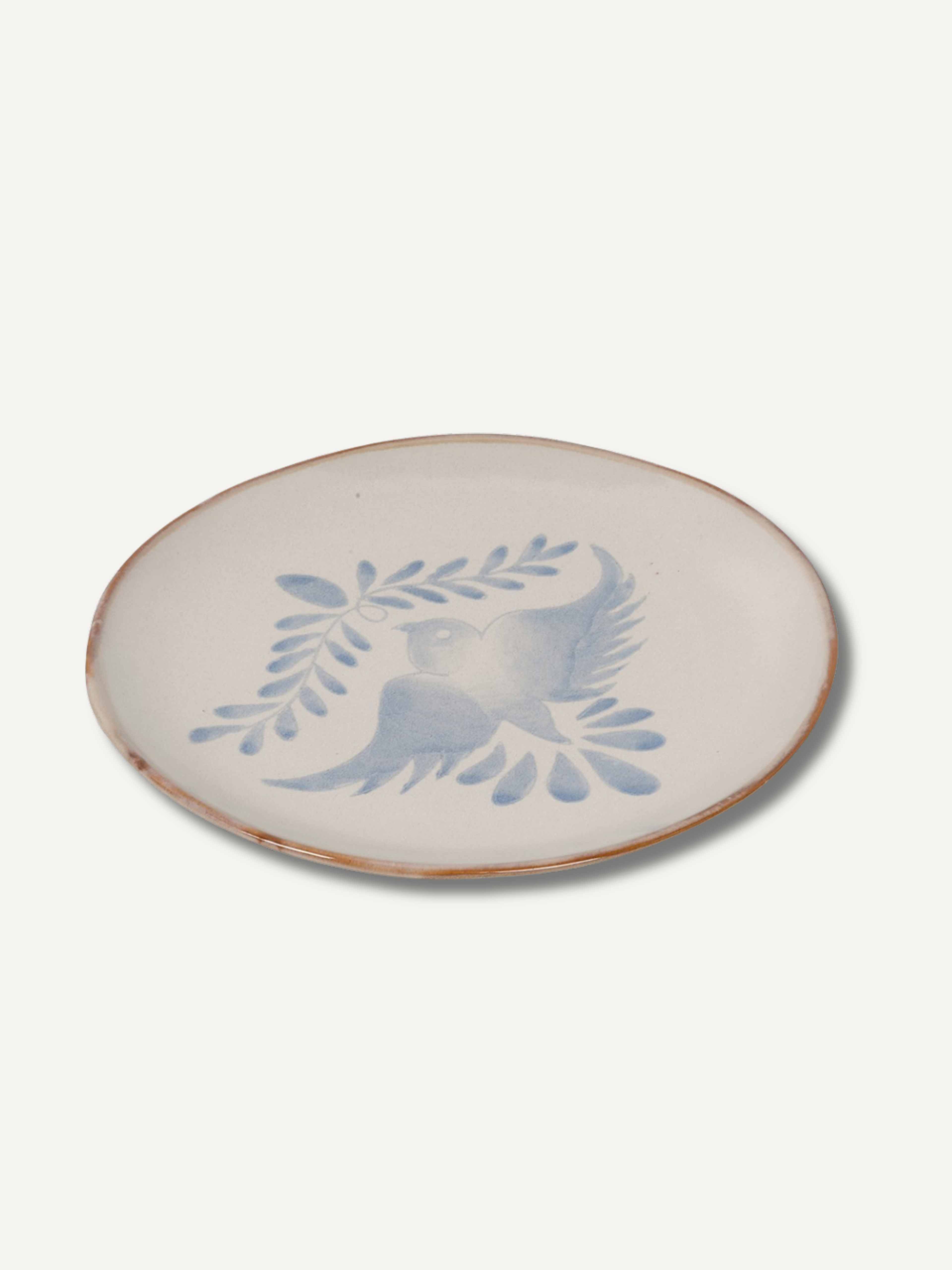 Ceramic plate with blue bird and leaf design on a white background
