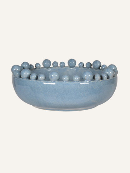 Pale blue ceramic bowl with spherical bobbles  on a white background