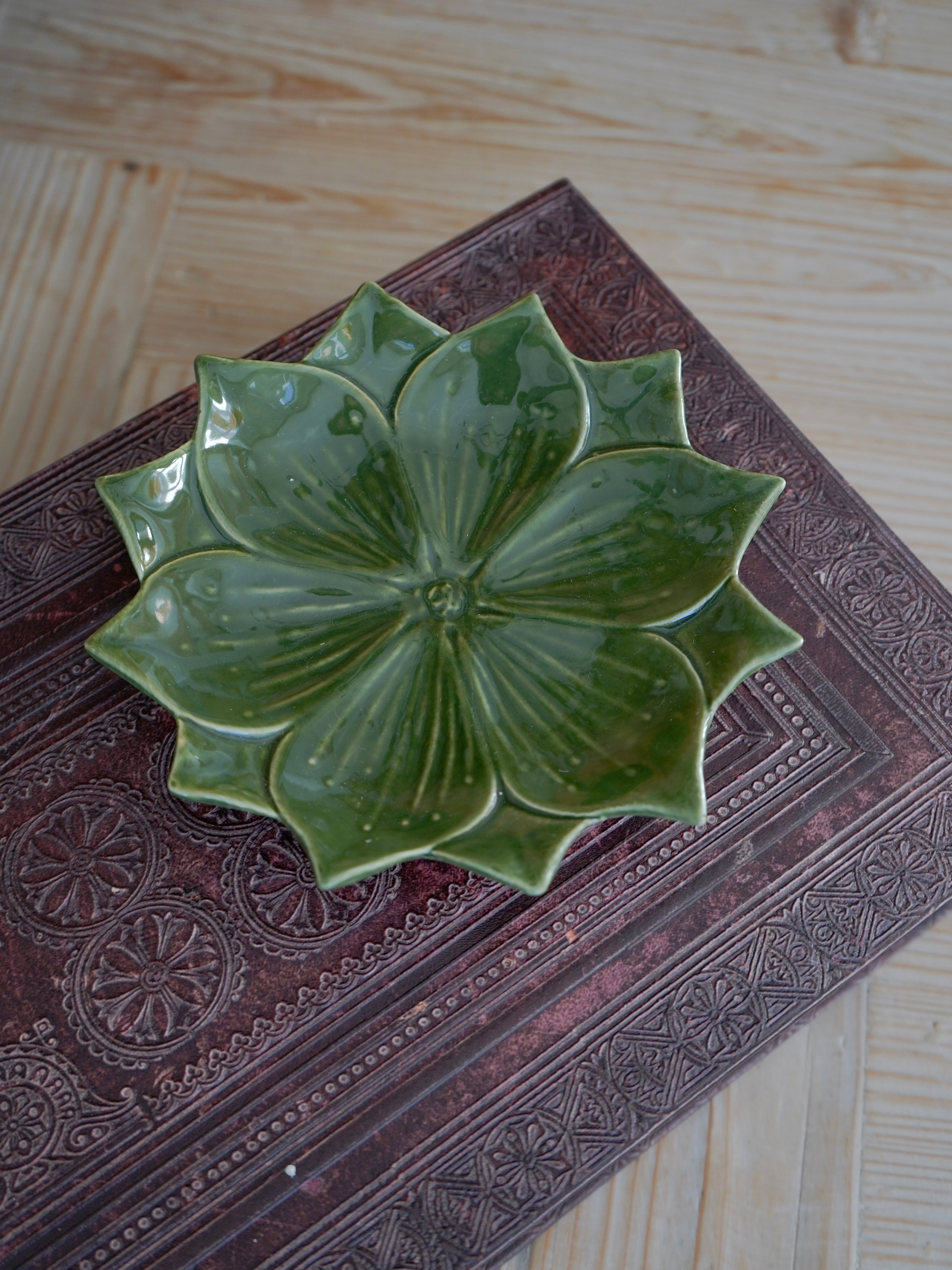 Green ceramic trinket dish on a textured surface