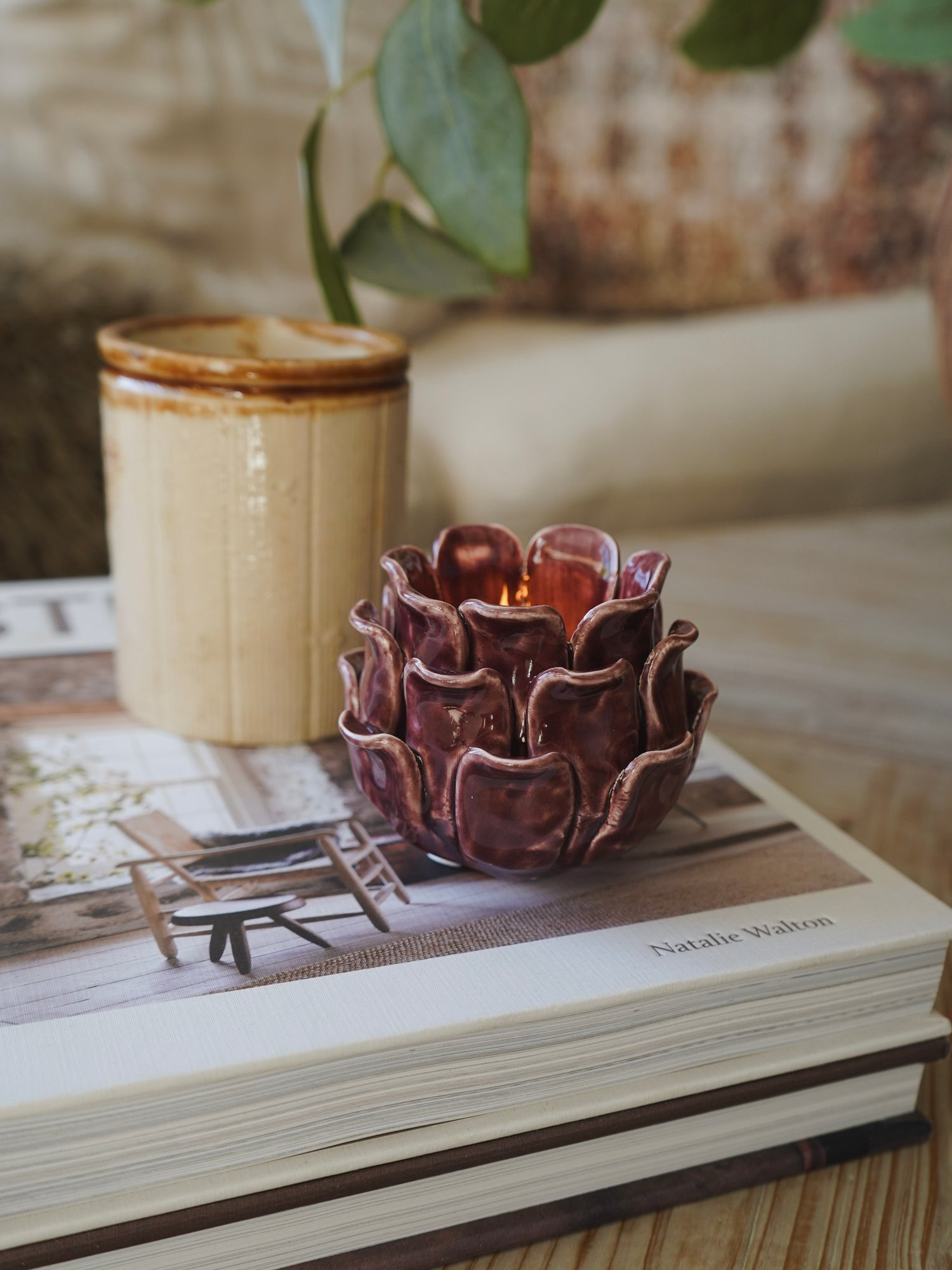 Decorative plum candle holder on a book with a blurred background