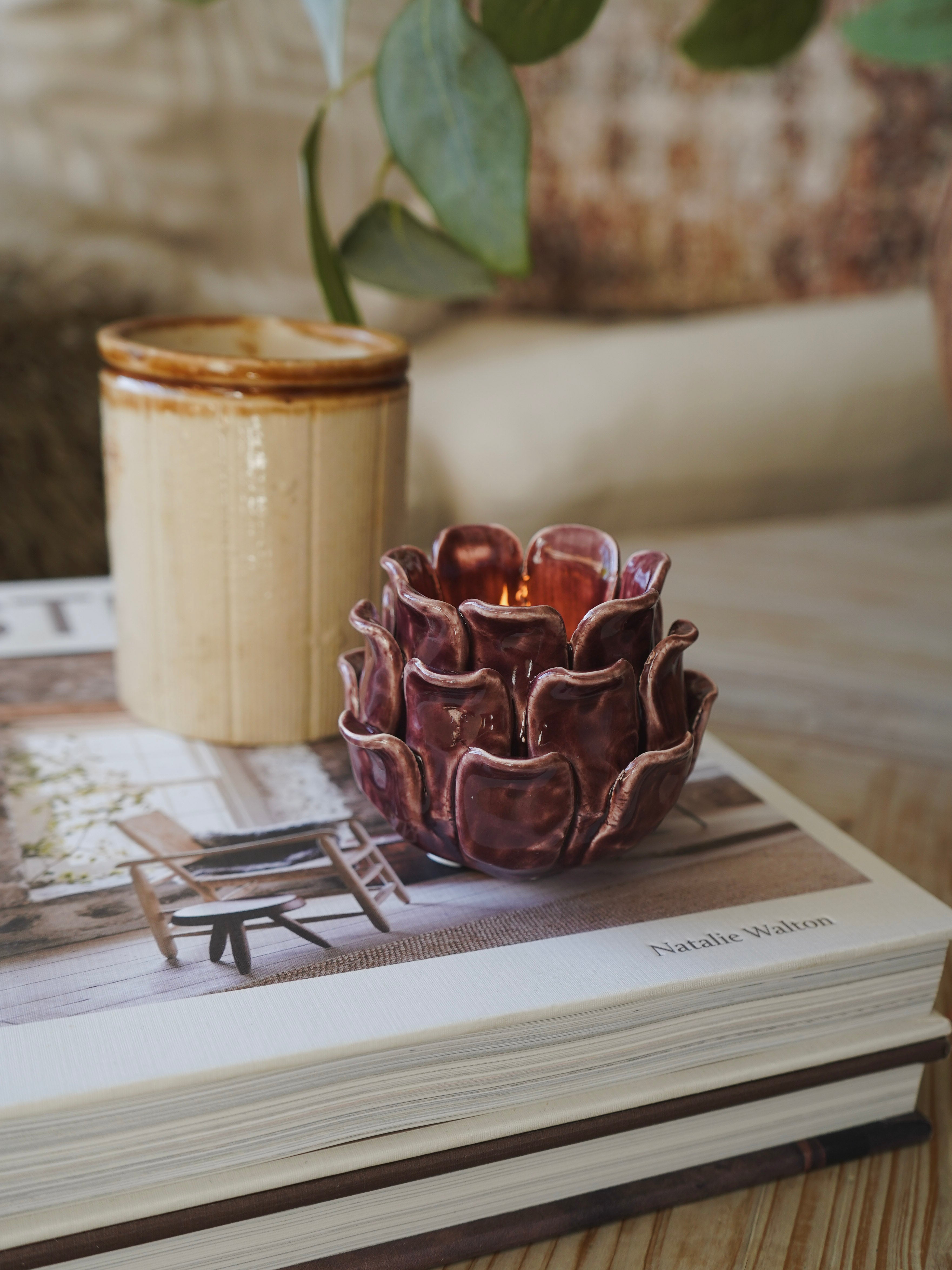 Decorative plum candle holder on a book with a blurred background