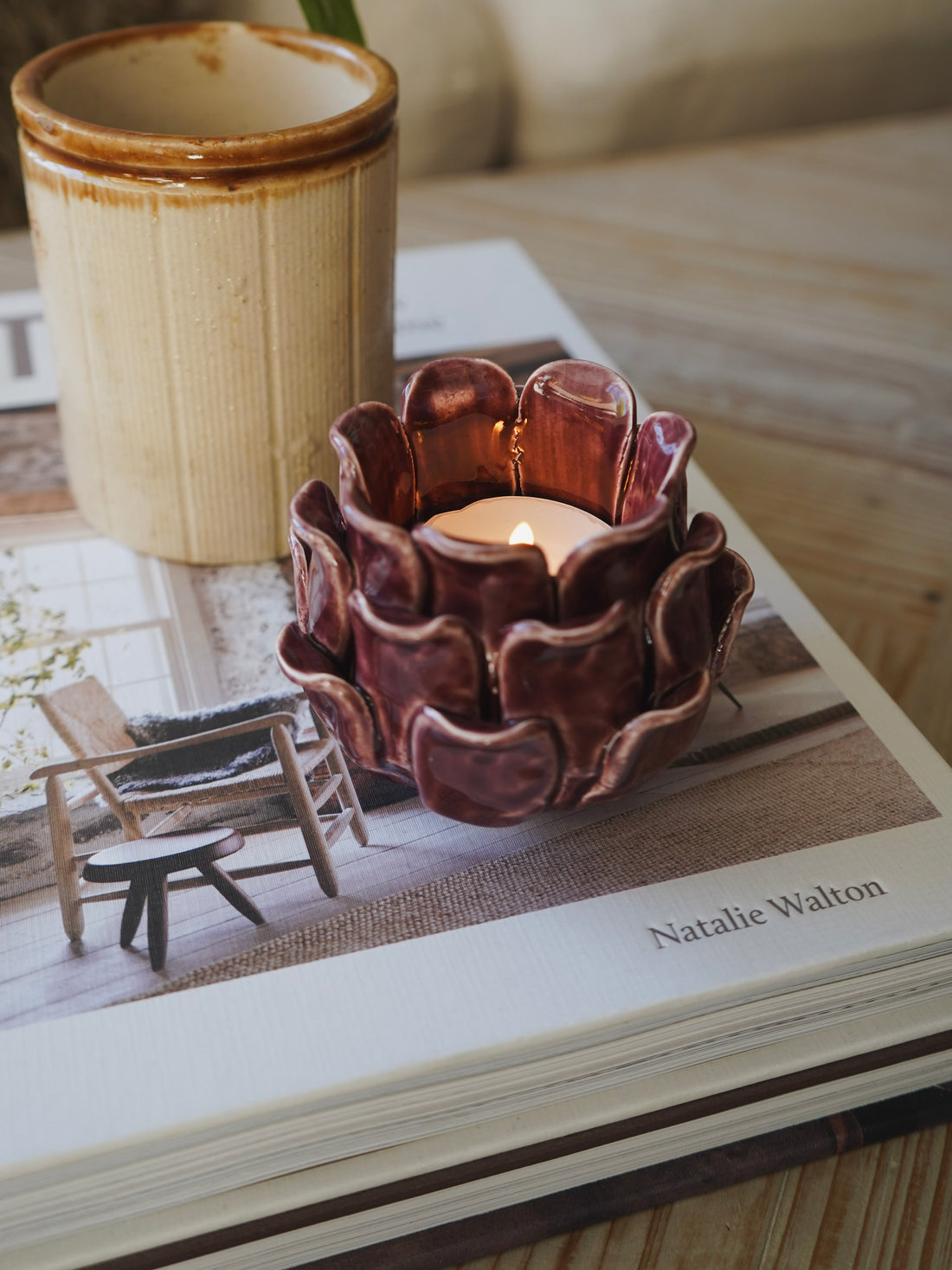 Ceramic candle holder on a book with a blurred indoor setting