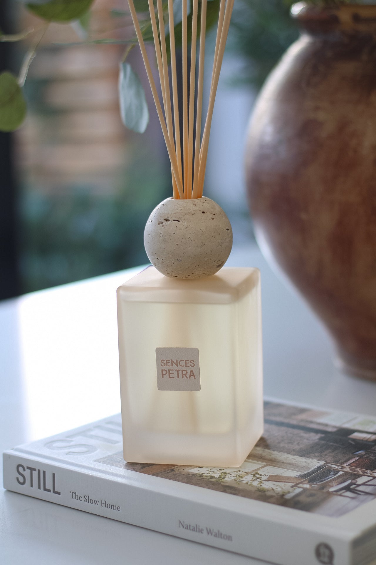 Reed diffuser on a book with a blurred background