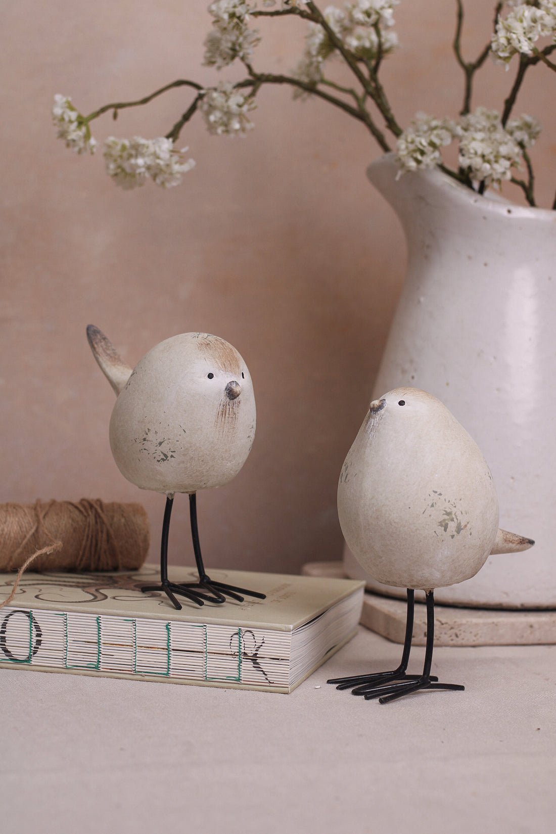 A set of two decorative stone-textured birds with long black legs, placed on a kitchen countertop.