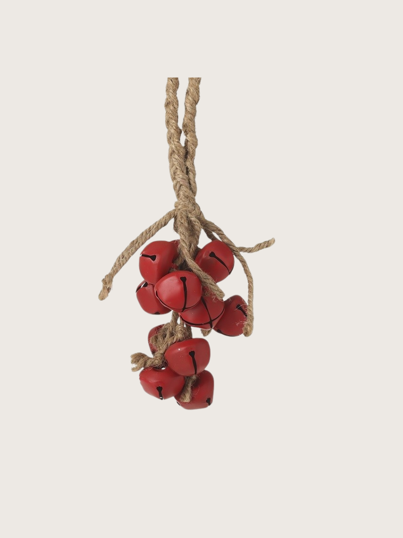 Red jingle bells on a string against a light beige background