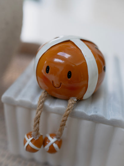 Decorative hot cross bun ornament with a smiling face on a white surface