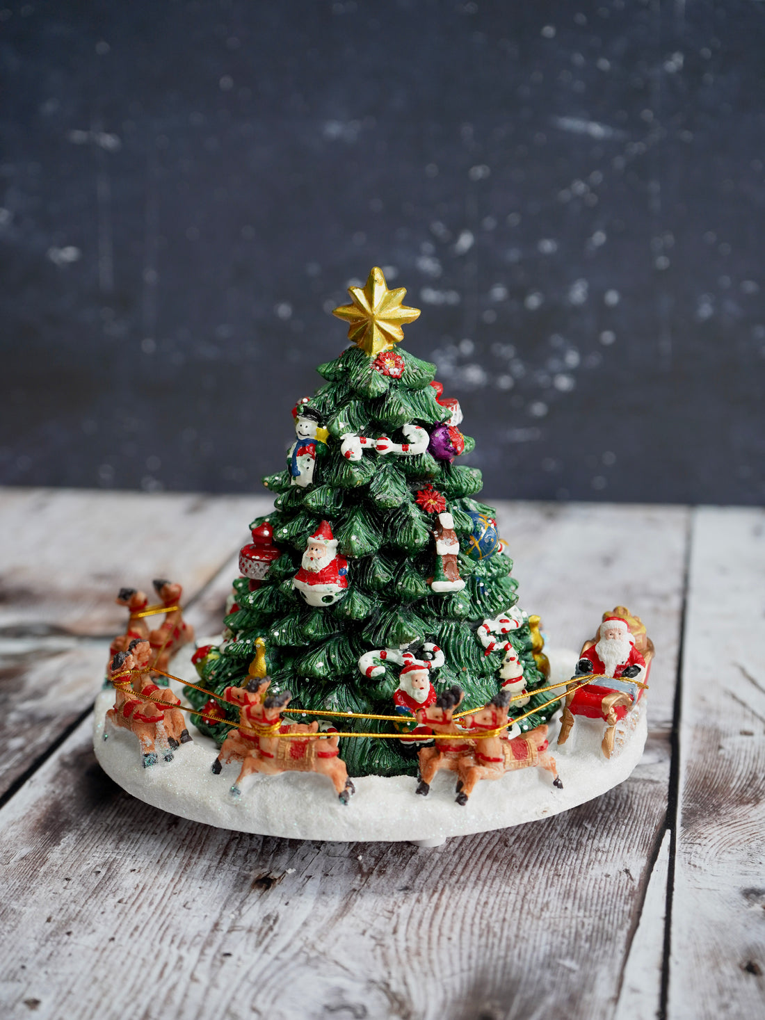 Decorative Christmas tree with Santa Claus and reindeer on a wooden surface