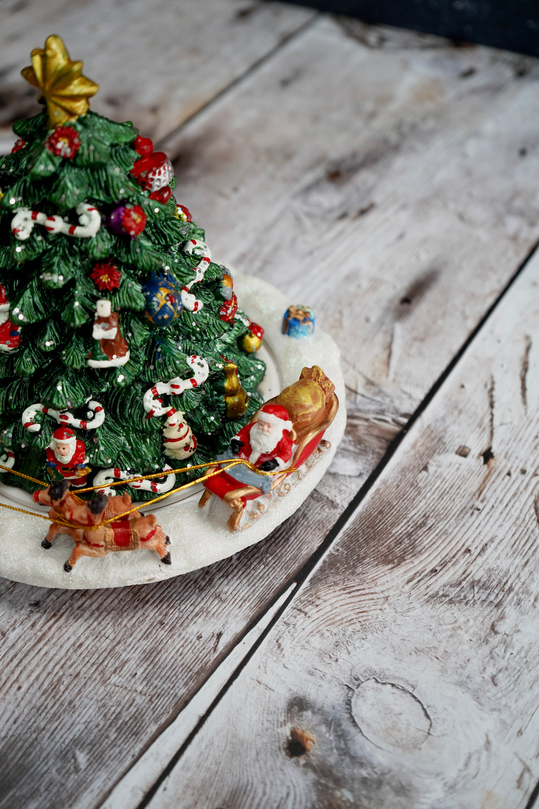 Decorative Christmas tree figurine with Santa Claus on a wooden surface