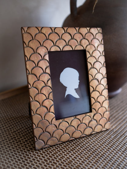 Decorative photo frame with fish scale pattern on a textured surface
