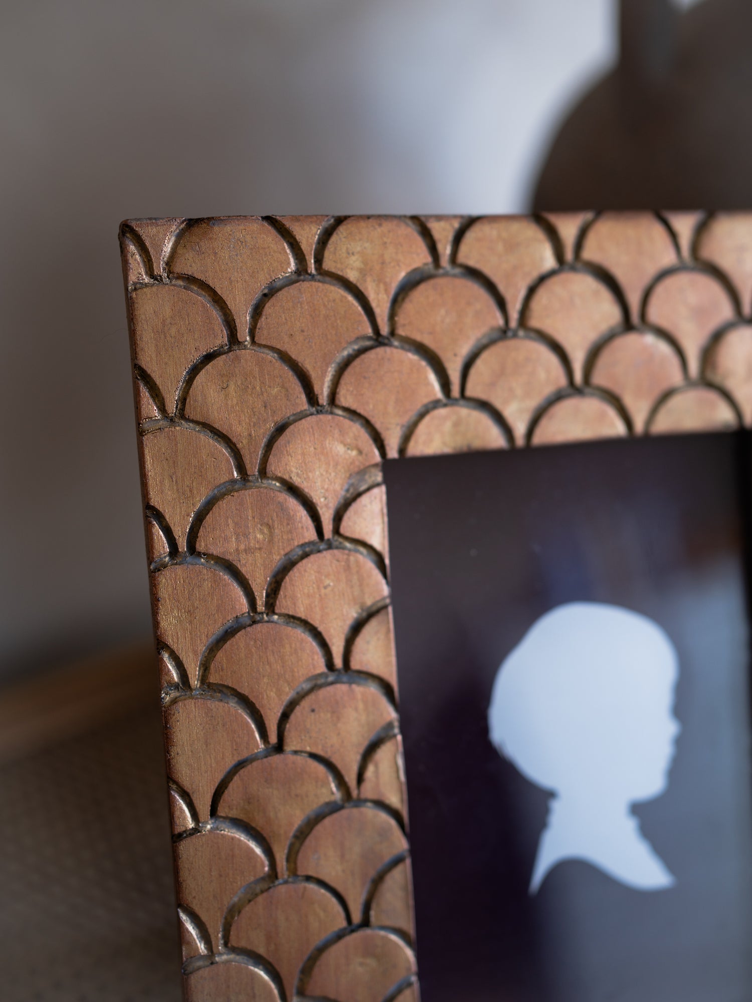 rose gold scales picture frame with geometric pattern holding a silhouette photo.