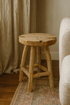 Wooden stool in a room with curtains and a rug