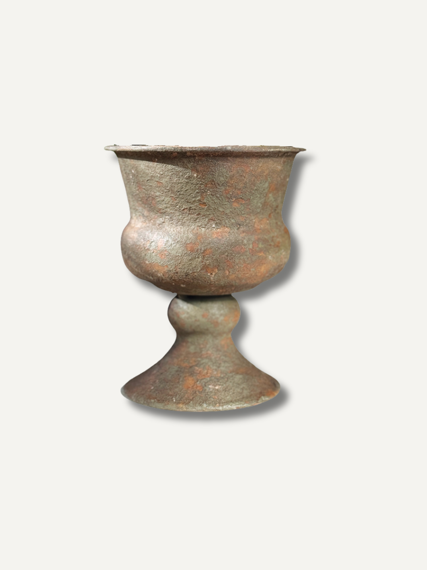 An antique-style bronze goblet or cup with a textured, weathered surface showing brown and green patina, set against a plain off-white background.