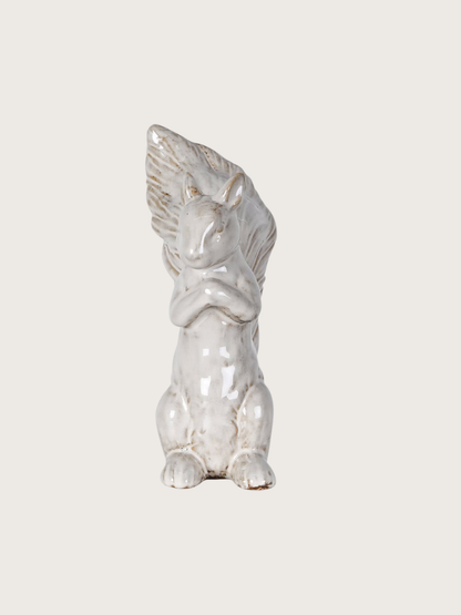 White ceramic squirrel on a light gray background