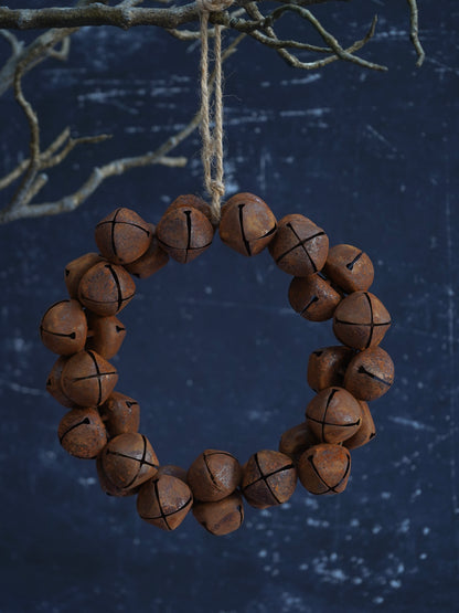Decorative wreath made of brown jingle bells on a dark blue background