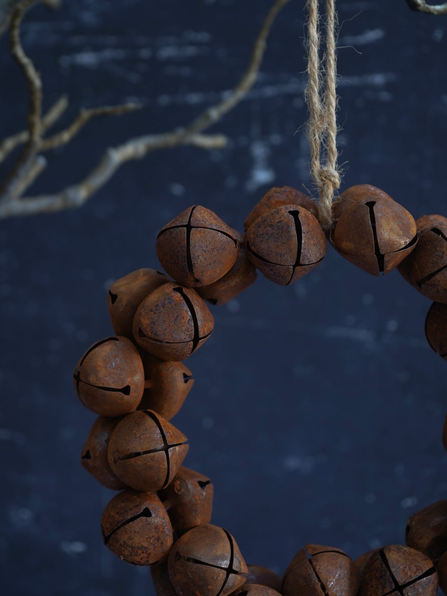 Rustic brown bell necklace hanging against a dark background