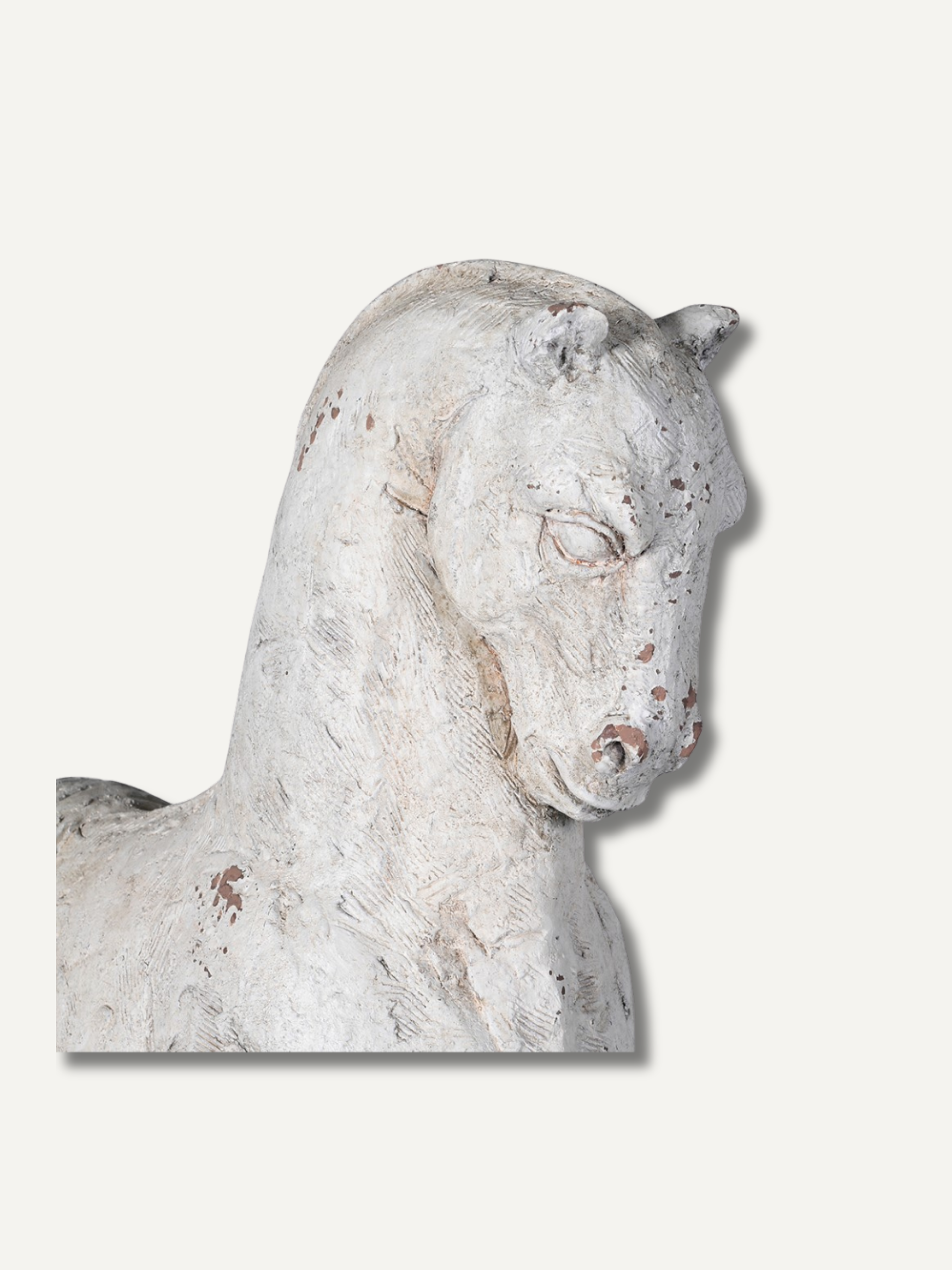 Stone sculpture of a horse head on a light gray background