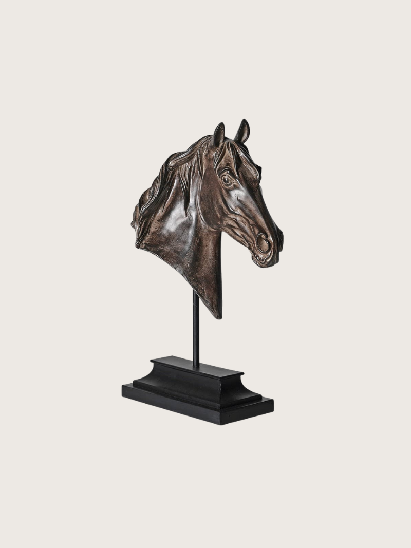 Bronze horse head sculpture on a stand against a light gray background