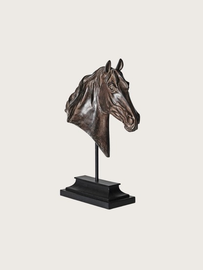 Bronze horse head sculpture on a stand against a light gray background