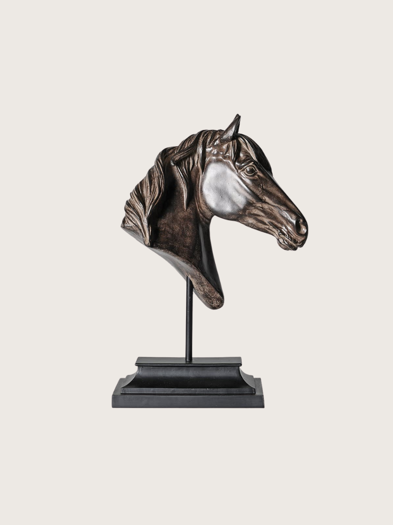 Bronze horse head sculpture on a stand against a white background