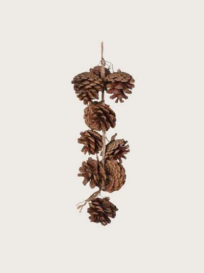 Decorative hanging of pine cones on a beige background