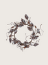 Decorative wreath with floral and bird designs on a light background