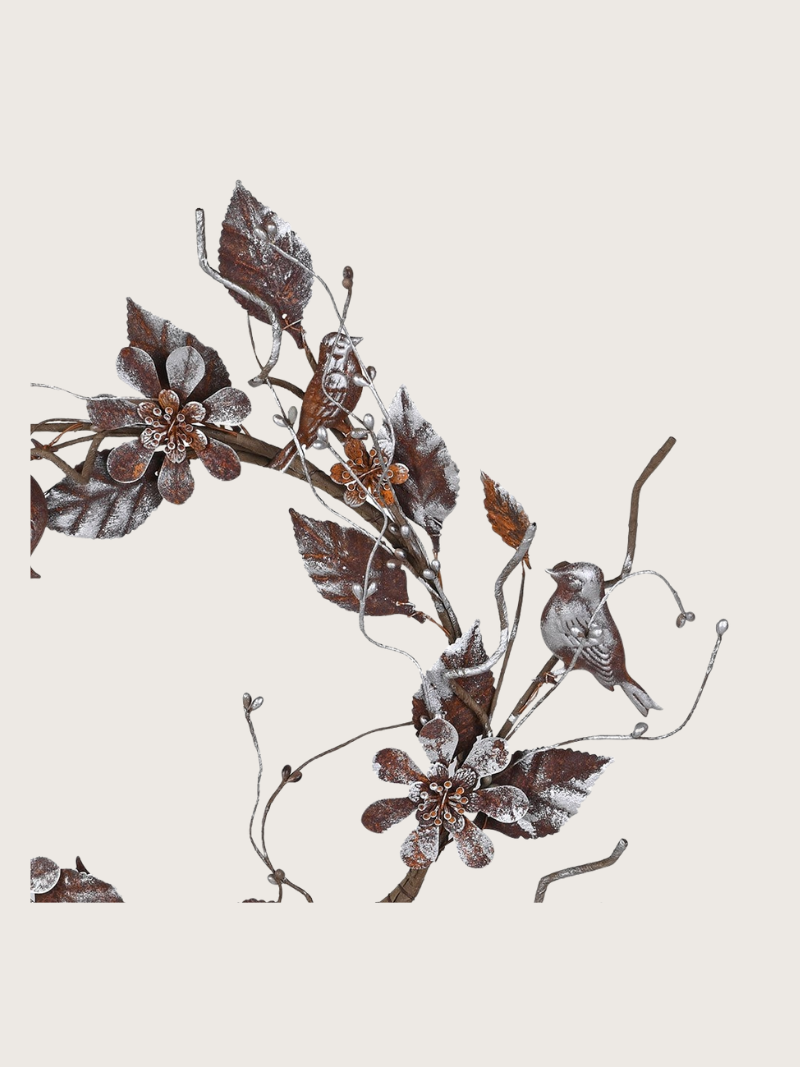 Decorative metal wall art with floral and bird designs on a beige background