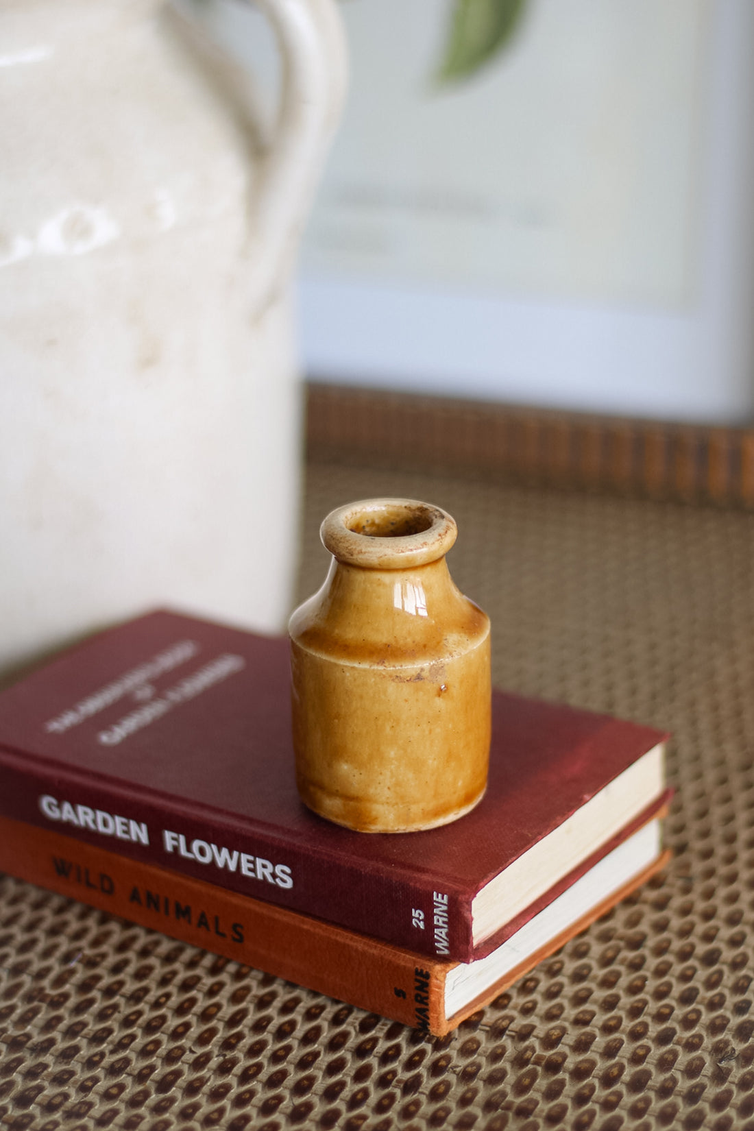 Small brown ceramic bottle on a book with a blurred background