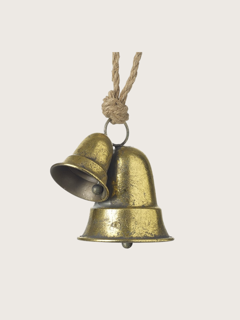 Pair of brass bells on a rope against a light background
