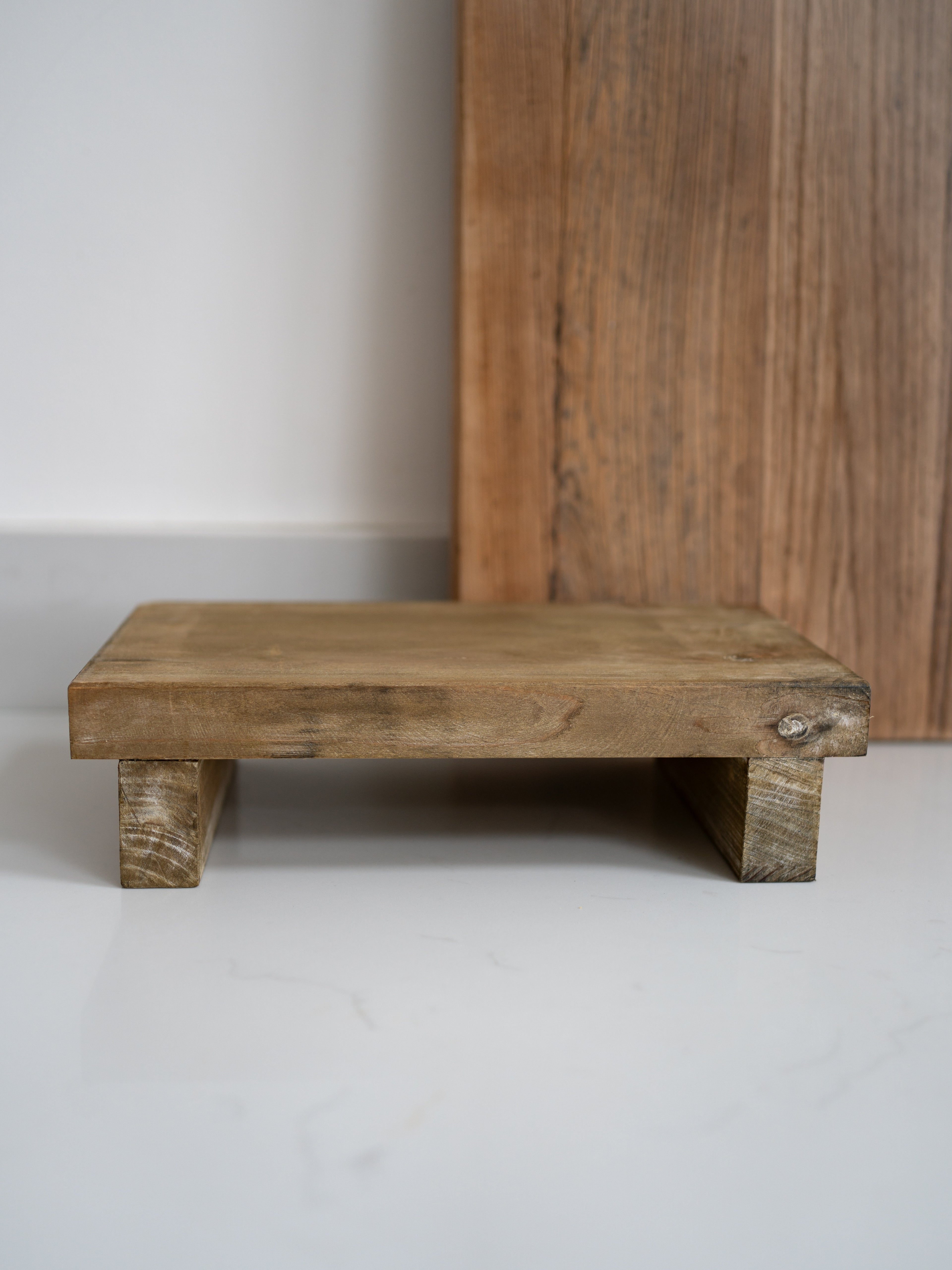 Wooden display board against a plain wall