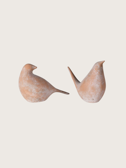 Two ceramic birds on a light beige background