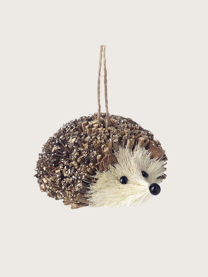 Decorative hedgehog ornament hanging on a string against a light background