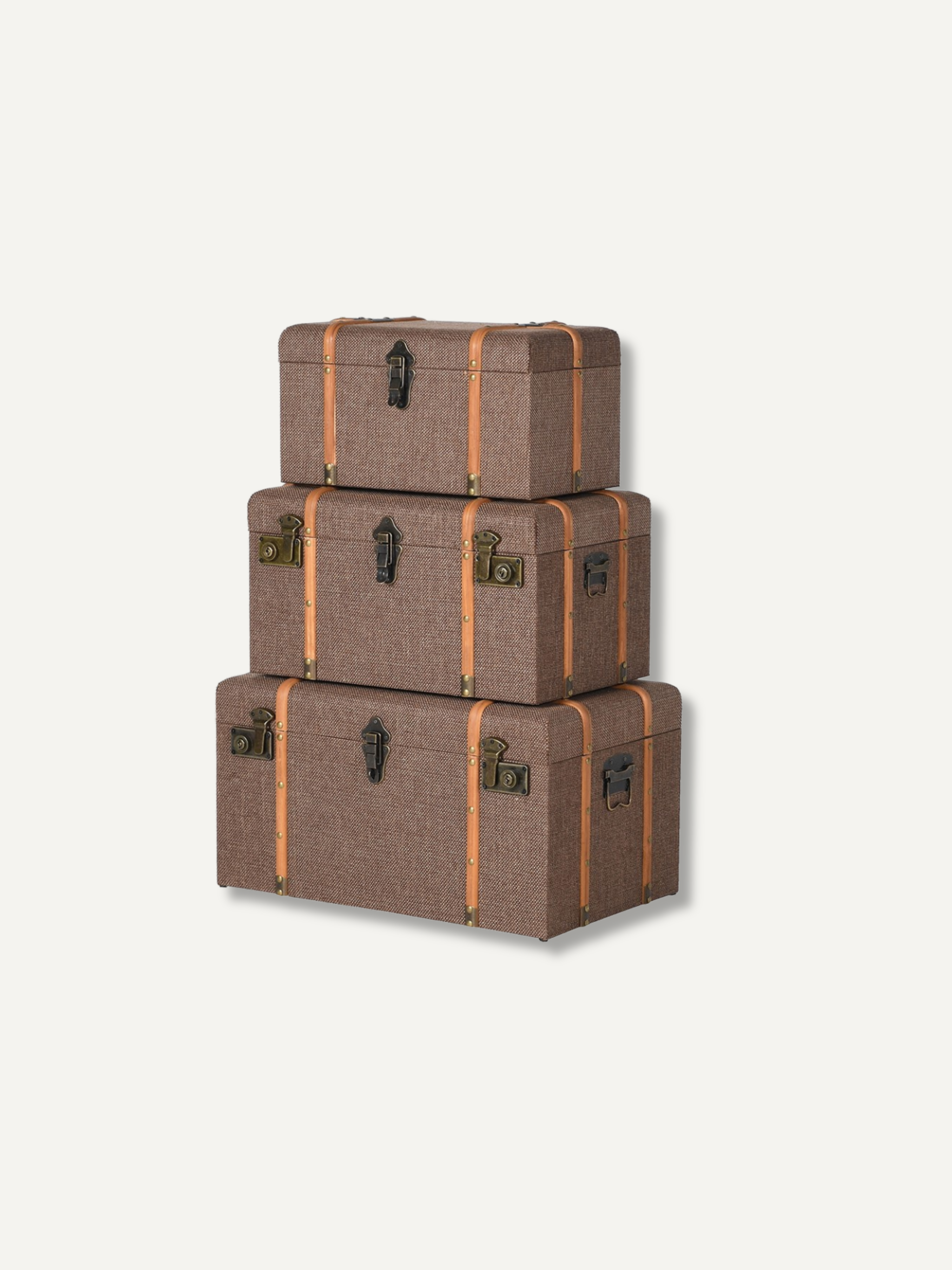 Three stacked vintage-style storage trunks in a textured brown fabric with tan straps and dark metal hardware, shown on a plain light background.