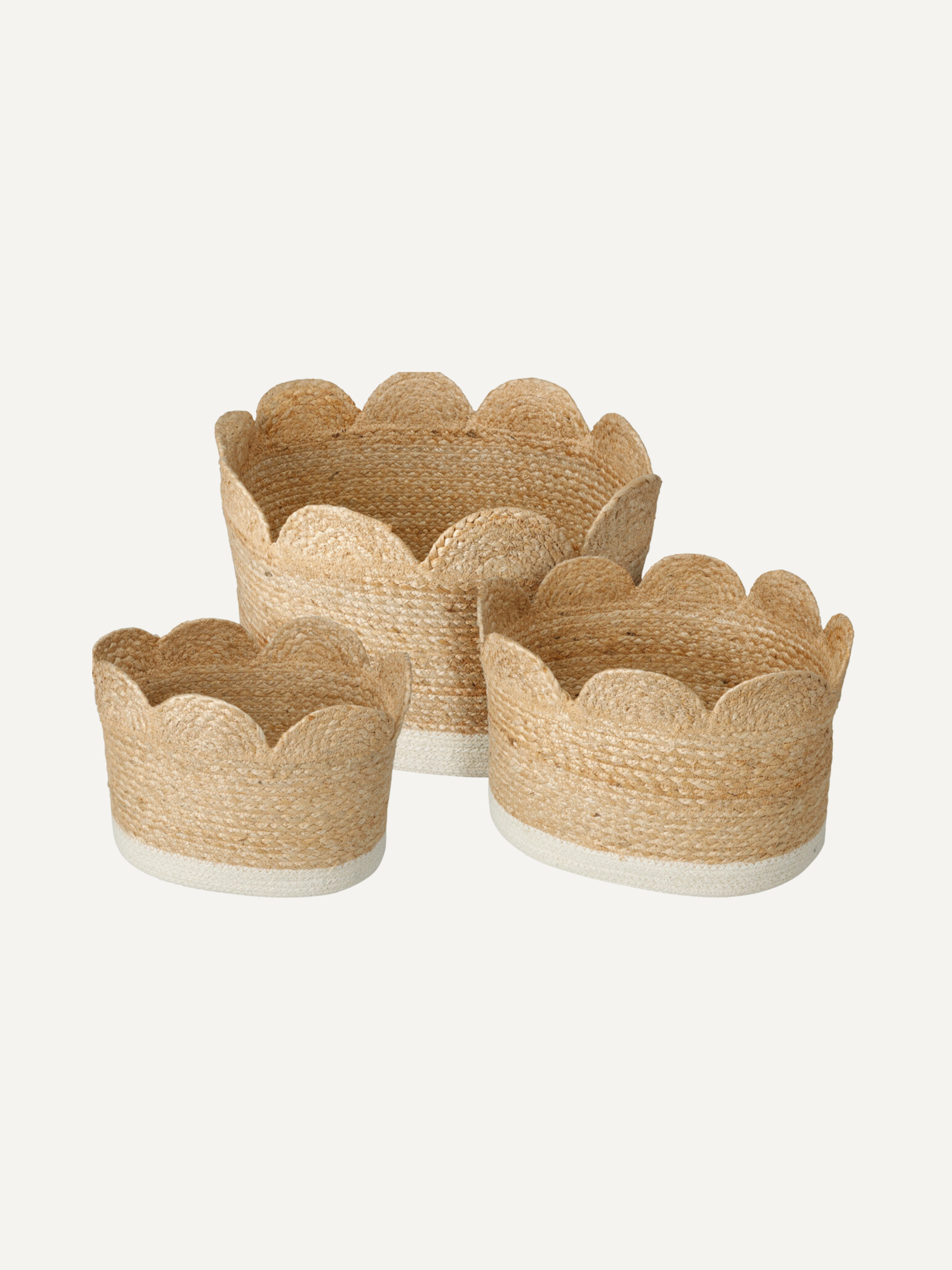 Set of three woven seagrass storage baskets with scalloped edges on a white background