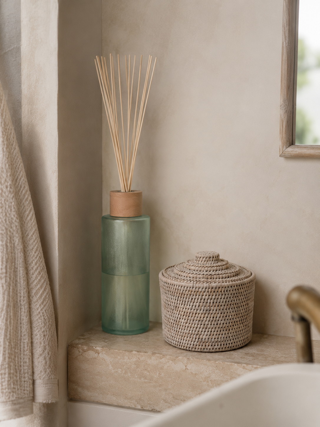 Decorative items including a green diffuser with reeds and a woven basket on a bathroom shelf.