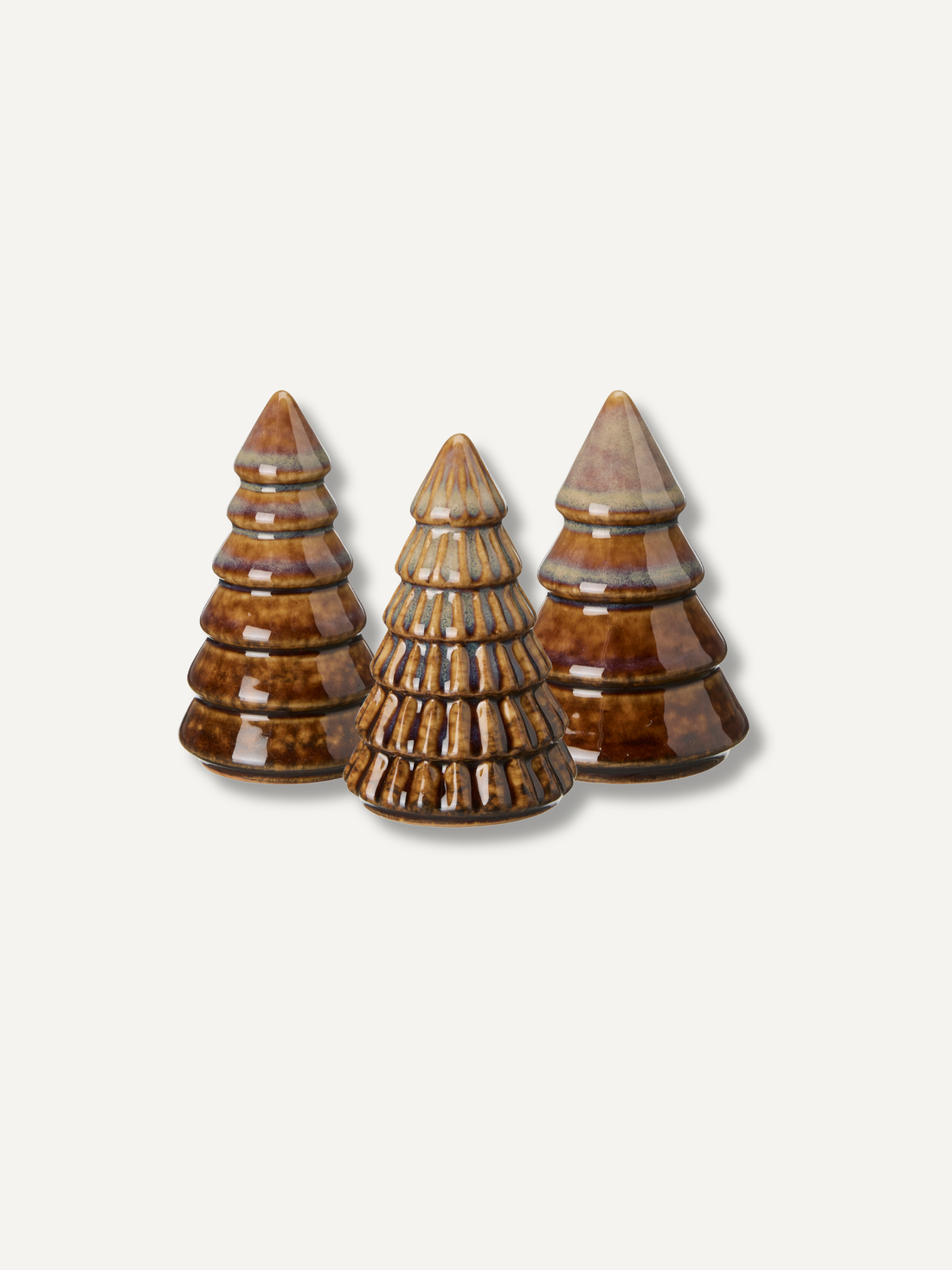 Three small decorative christmas tree-shaped objects with a glossy brown and beige marbled finish, arranged on a light gray background.