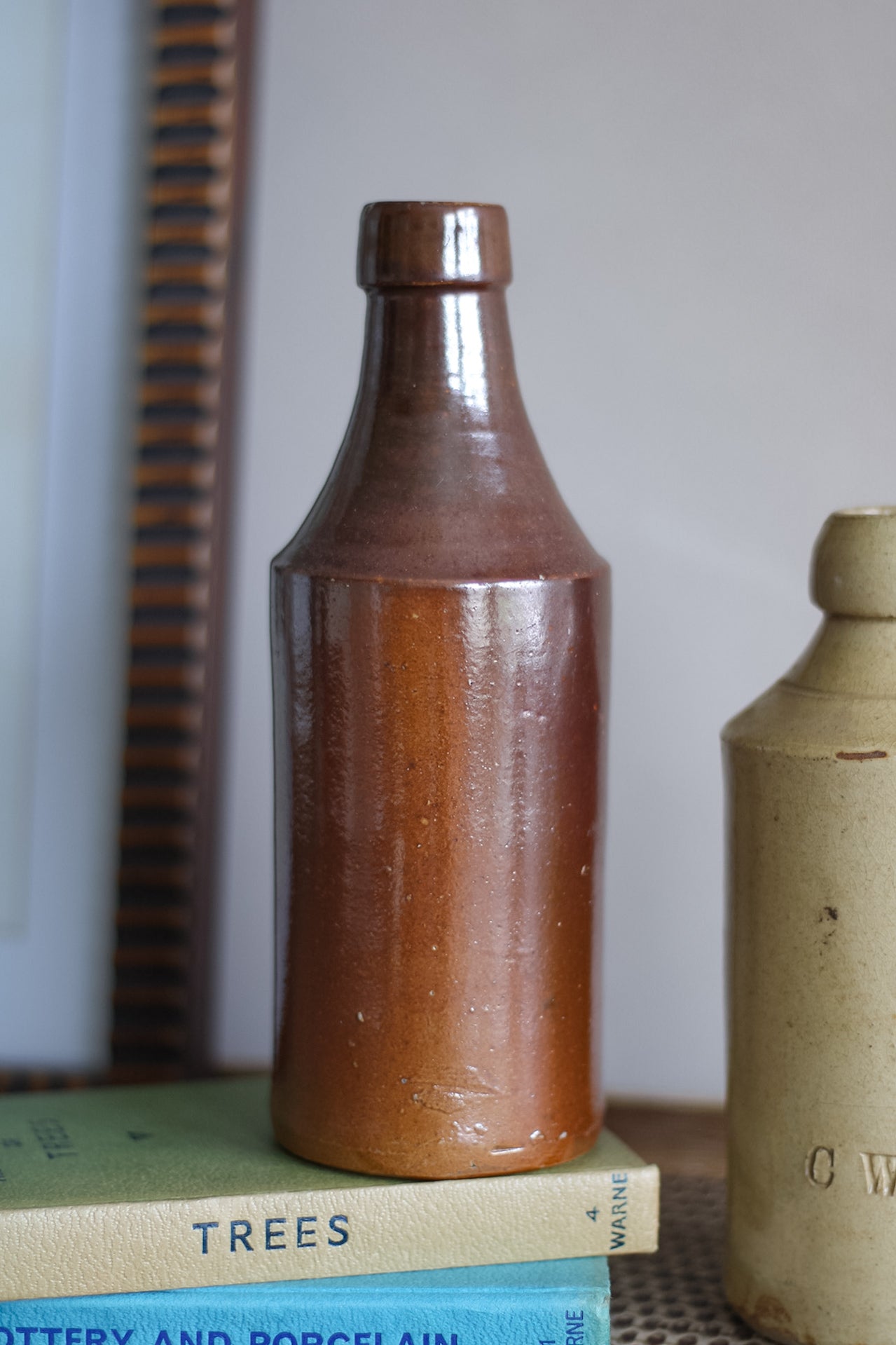 Brown ceramic bottle on a stack of books with a blurred background