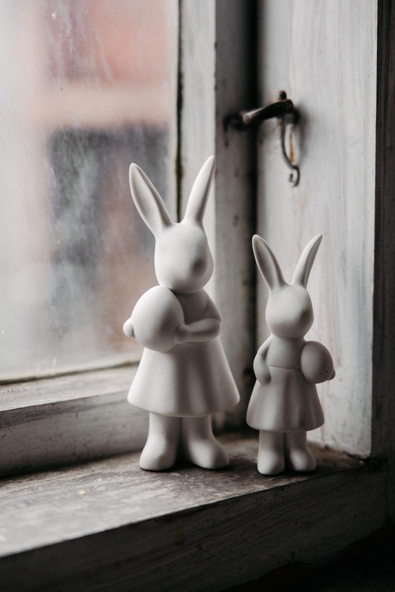 Set of white ceramic bunnies with easter egg