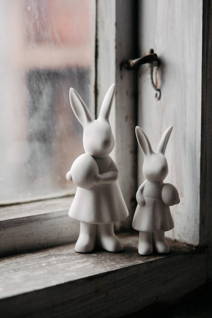 Set of white ceramic bunnies with easter egg