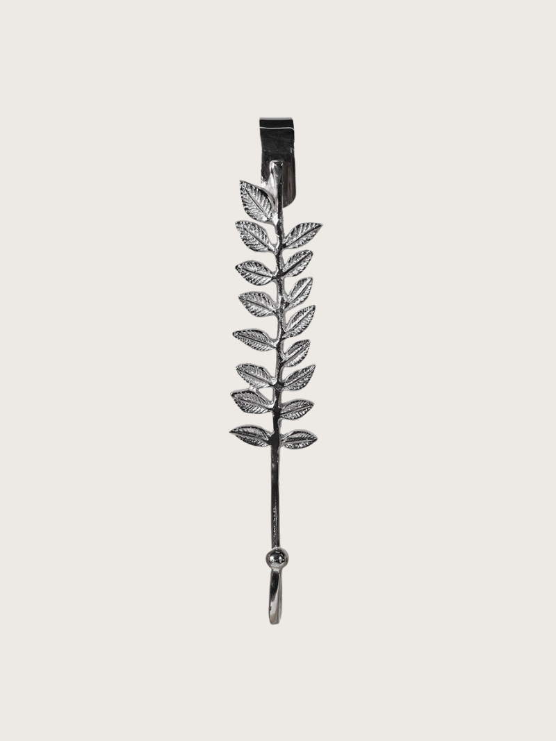 Decorative metal leaf-shaped hook on a light gray background