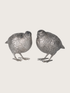Two silver bird figurines on a light gray background