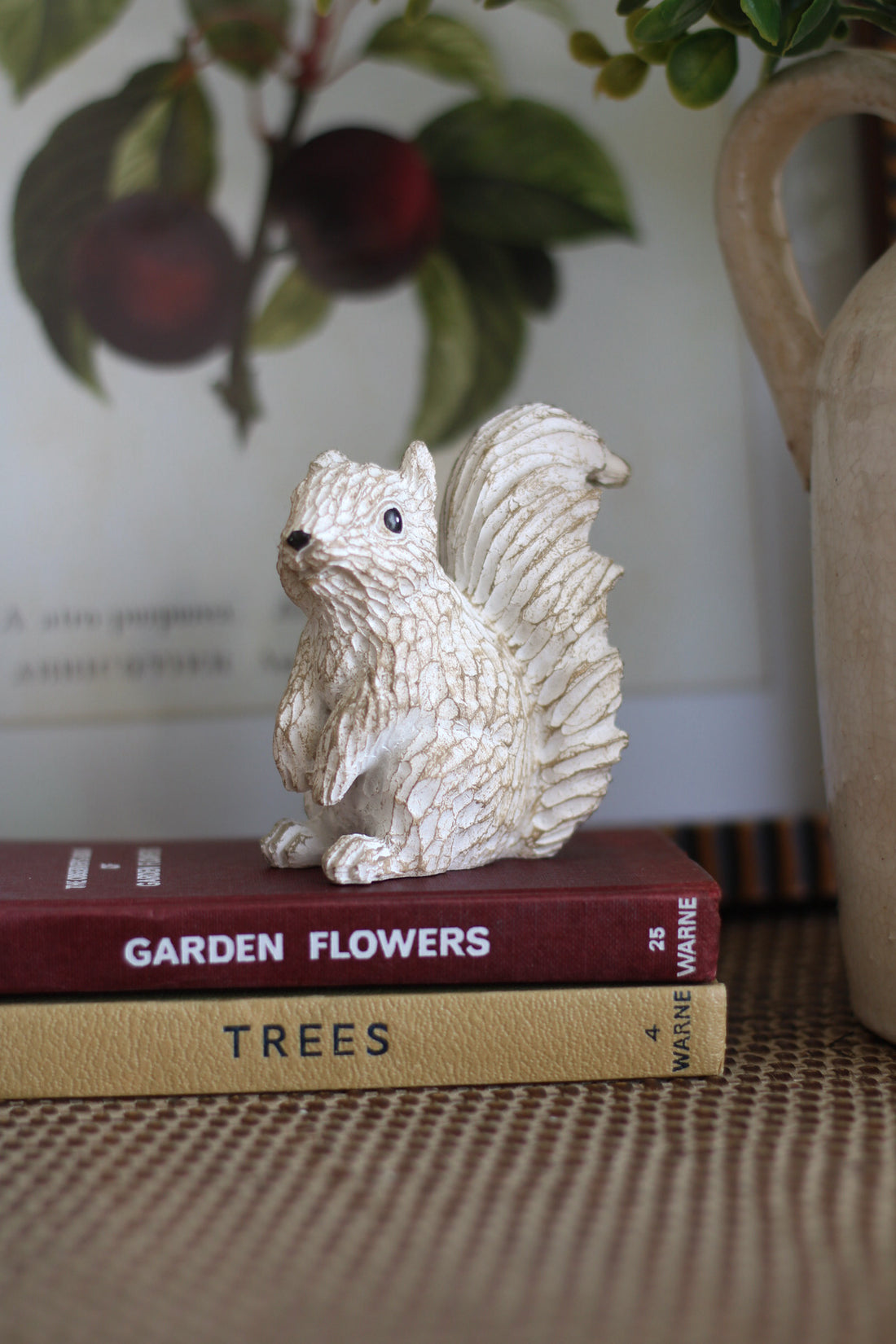 Decorative squirrel figurine on top of books with a blurred background
