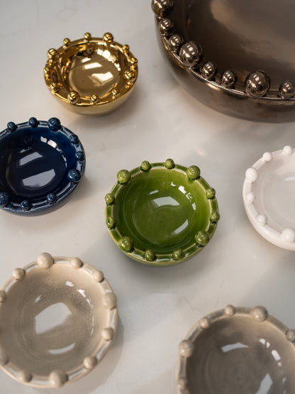Collection of small ceramic bobble bowls in various colors on a light surface