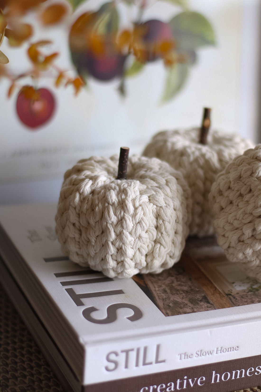 Cream knitted pumpkins on a book titled &