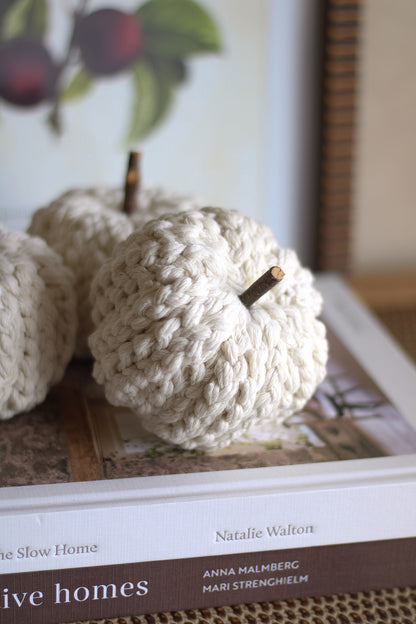 Knitted apples on a book with a blurred background