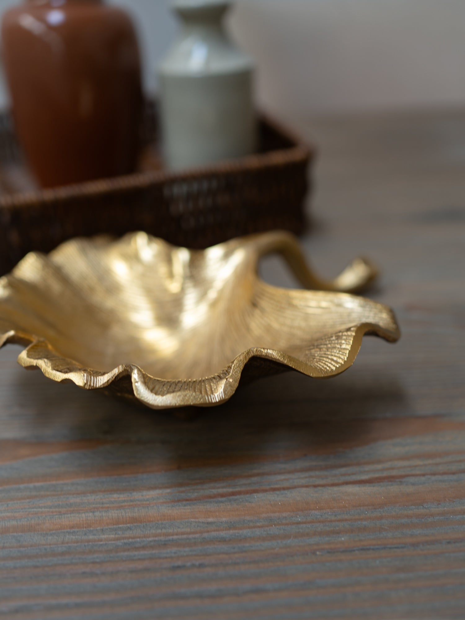 Gold leaf-shaped dish on a wooden surface with blurred background