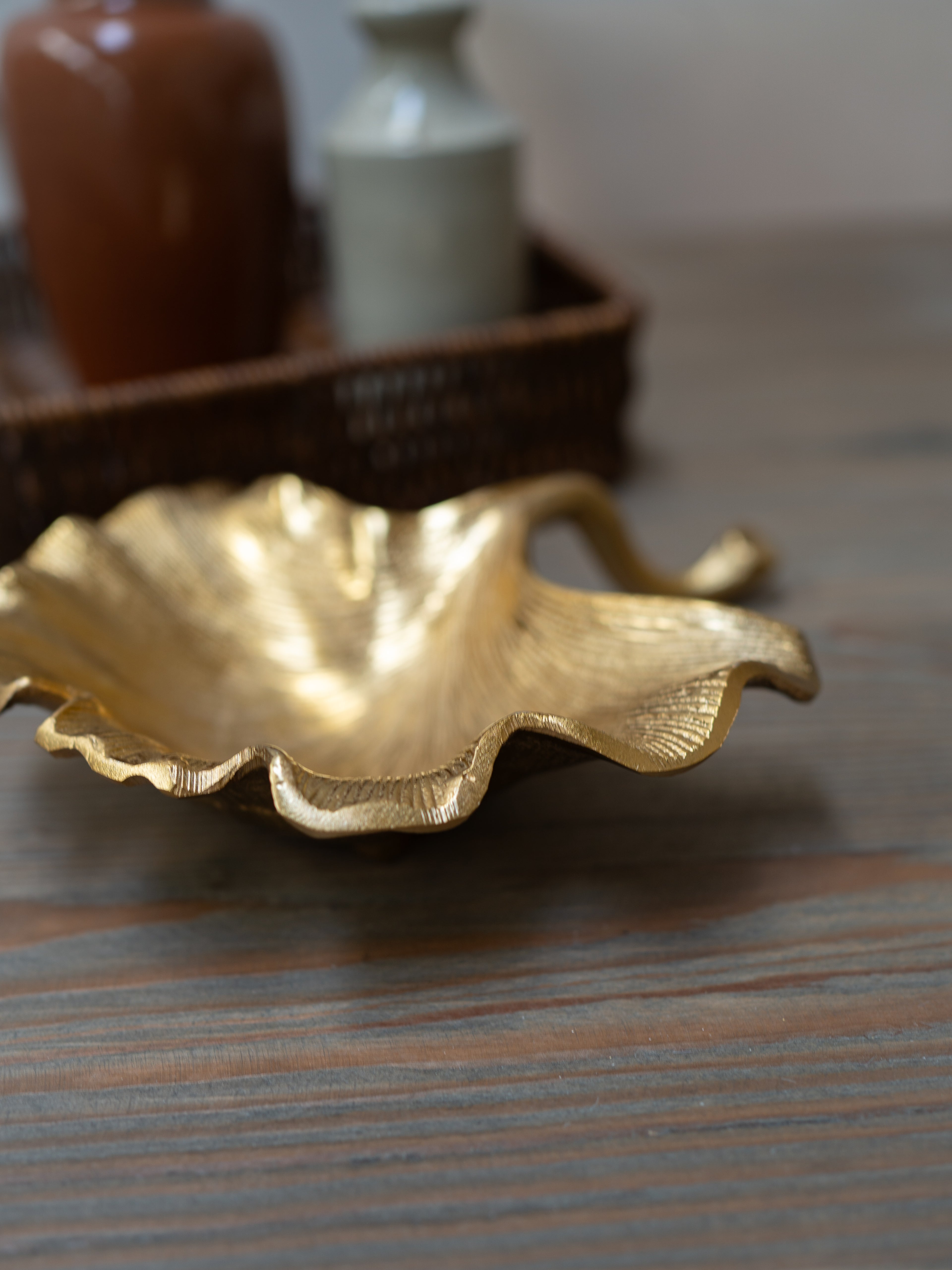 Gold leaf-shaped dish on a wooden surface with blurred background
