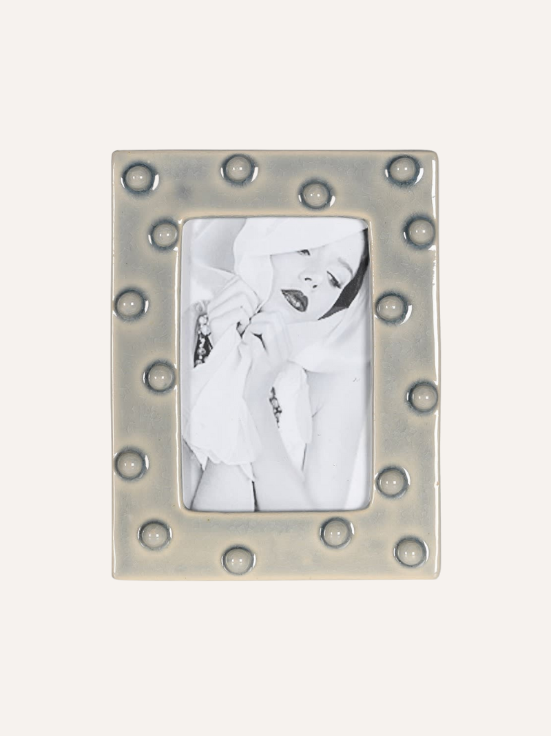 Decorative  grey ceramic dotty photo frame with a white background