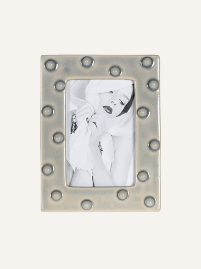 Decorative  grey ceramic dotty photo frame with a white background